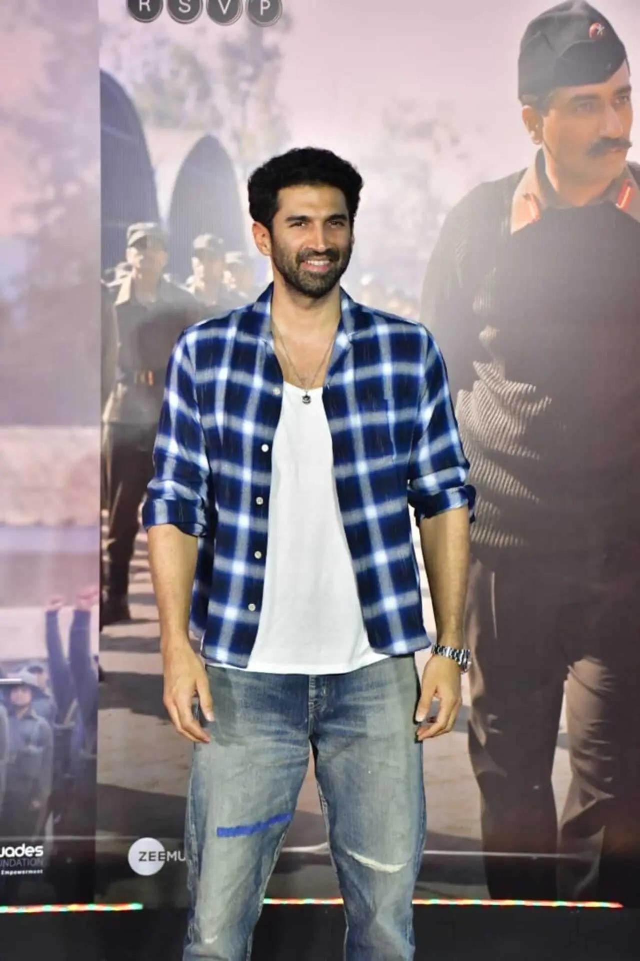 He wore a white T-shirt along with a checkered shirt jacket and jeans