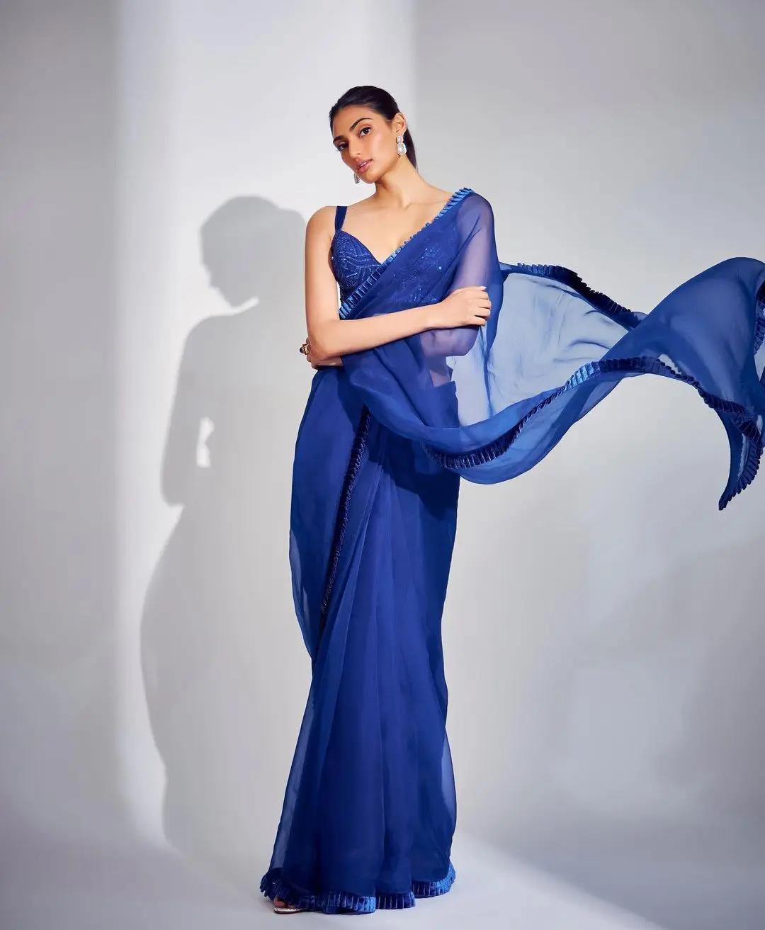 She paired it with a shiny, strappy sequined blouse in the same blue shade.