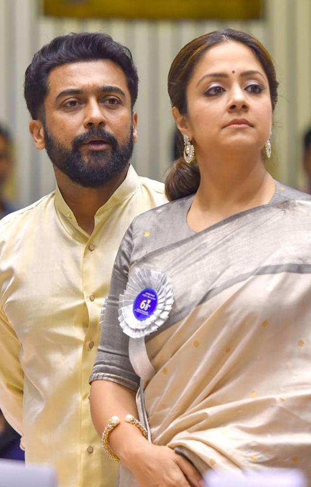 Experience the magnetic charisma of Jyothika and Surya in this captivating image of the power couple