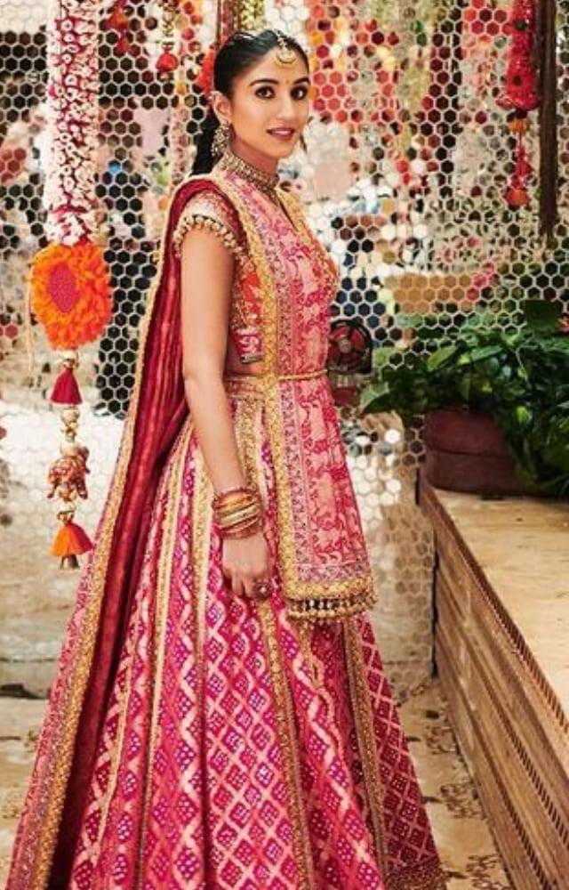 The bride to be Radhika Merchant looked elegant in an embroidered pink and tangerine lehenga.