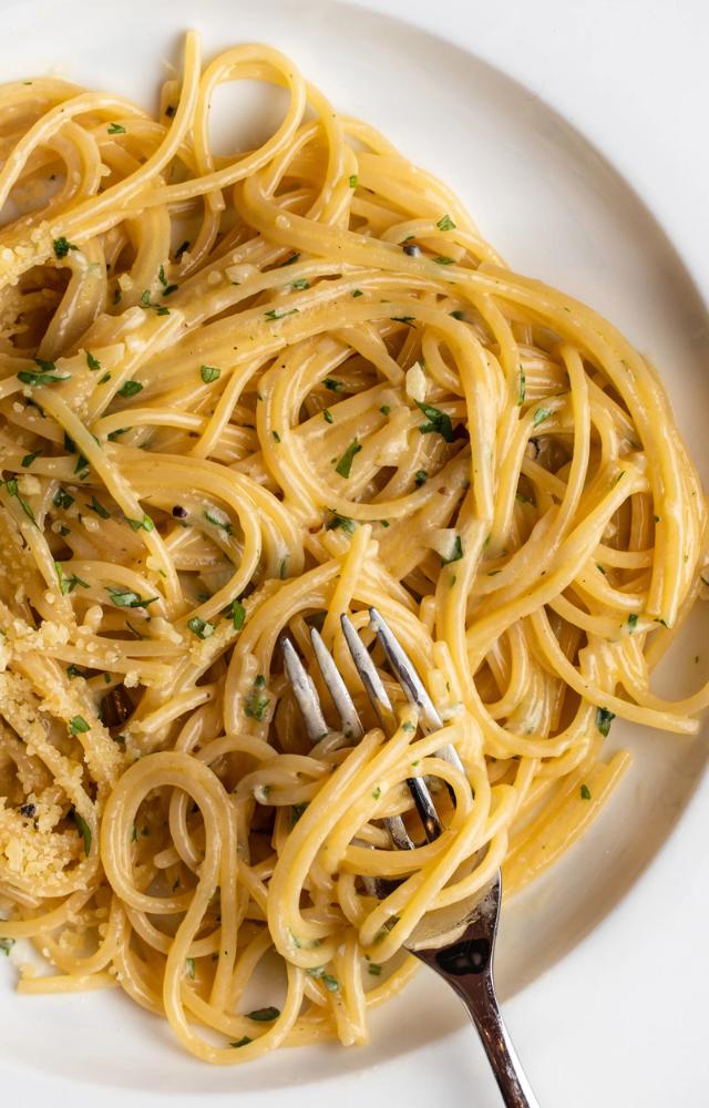 Cook spaghetti, toss in melted butter, minced garlic, and Parmesan. Add parsley for garnish. Its simple, savoury, and ready in under 15 minutes.