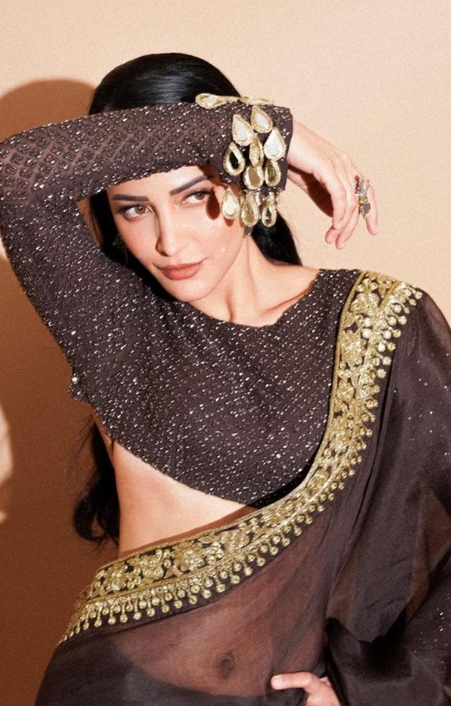 Her choice of jewelry, like jhumkas and traditional footwear, complements her looks.