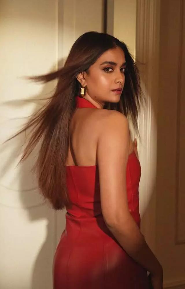 The fitted silhouette of the dress beautifully highlights her curves, creating a sleek and polished appearance.