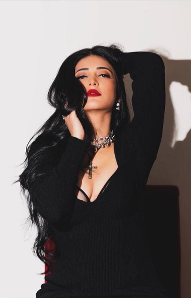 Unveil the captivating allure as Shruti Hassan radiates boldness and beauty in a black dress, accentuated by a delicate cross around her neck with cross