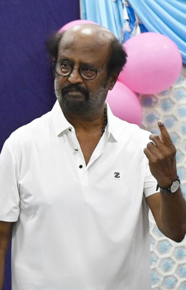 At a Chennai polling place, veteran actor Rajinikanth casts his vote in the first phase of the Lok Sabha elections and displays his inked finger.