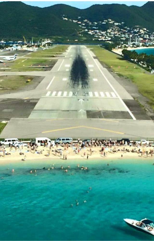 Planes fly just feet over beachgoers` heads before touching down—iconic and terrifying.
