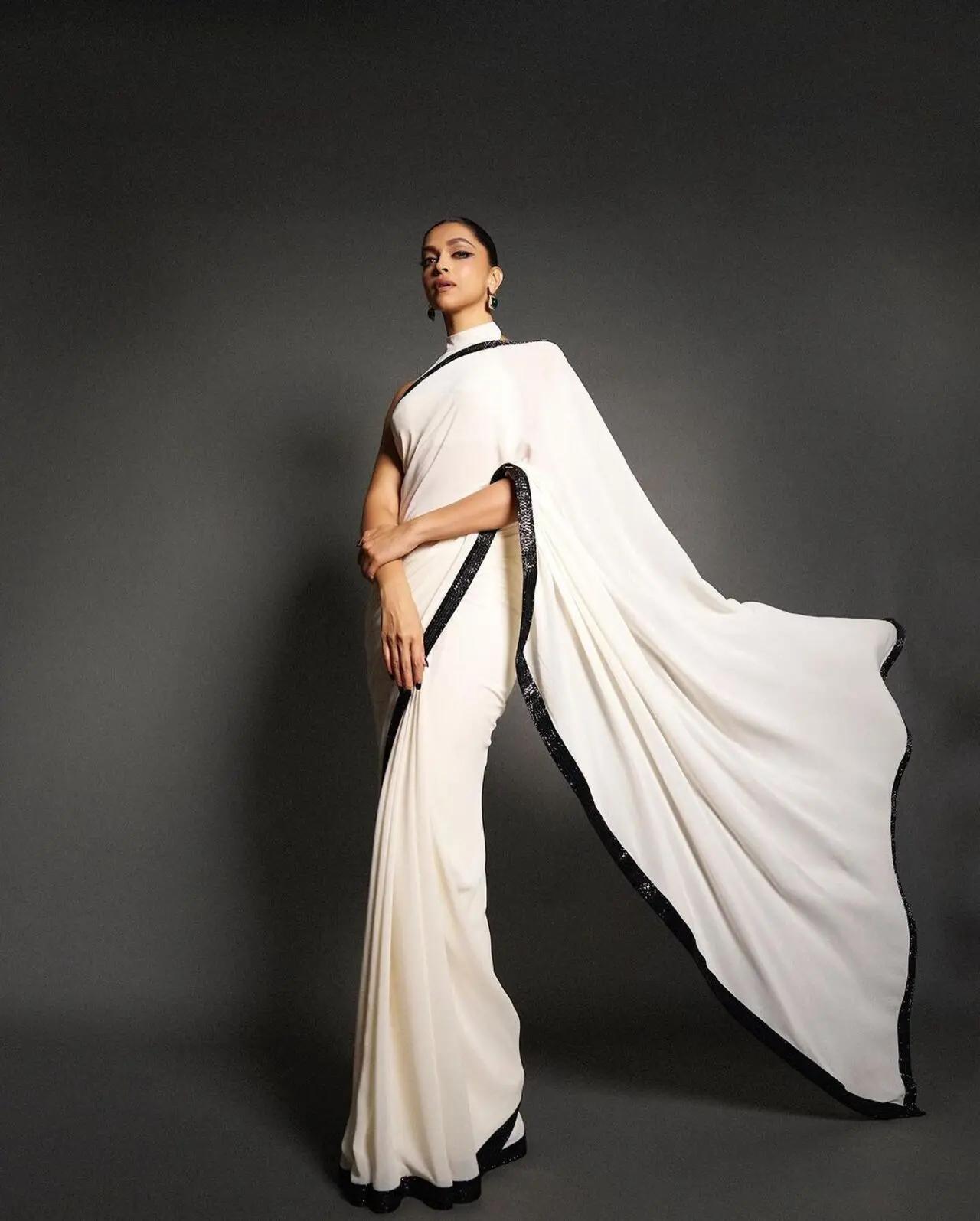 The plain white saree as sequin black border. The actress opted for dramatic eye makeup and green emerald earrings to complete the look