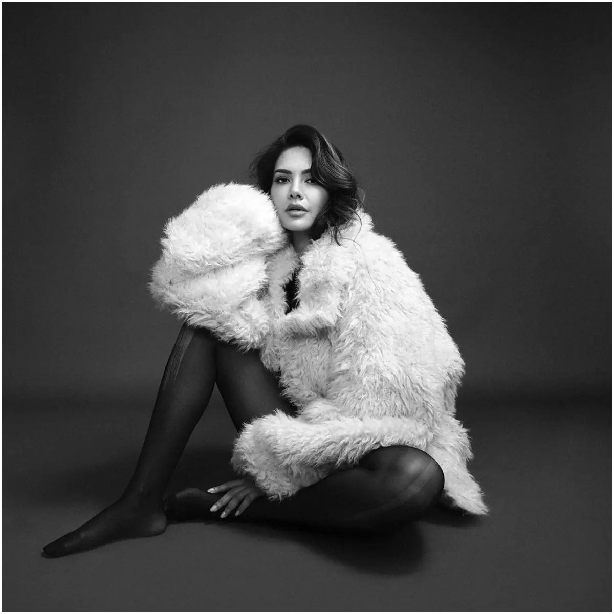 Esha channels Hollywood glam here, posing in a classic black and white look for a fashion shoot. The fur and sheer stockings combination is to die for