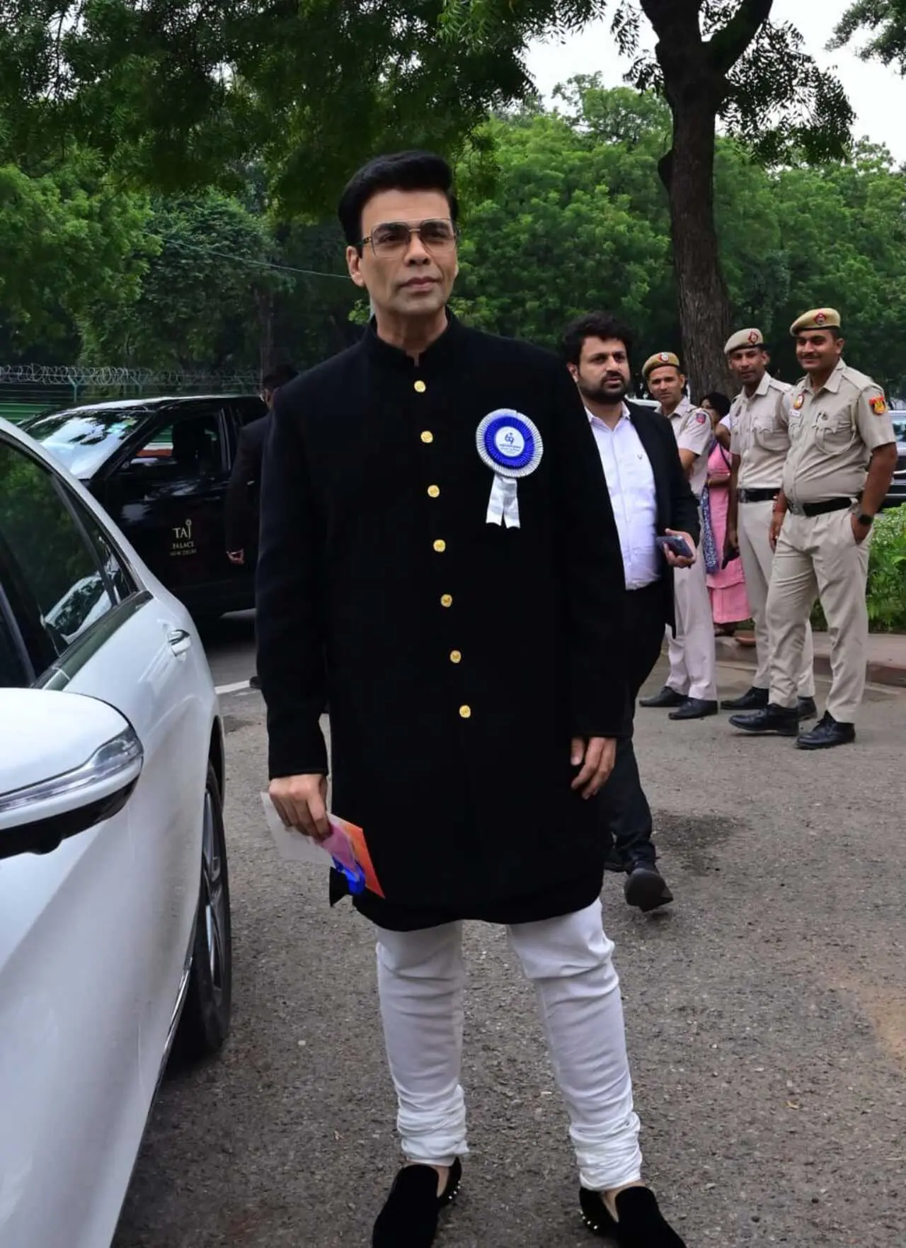 Karan wore a black suit paired with matching shoes and white pajamas
