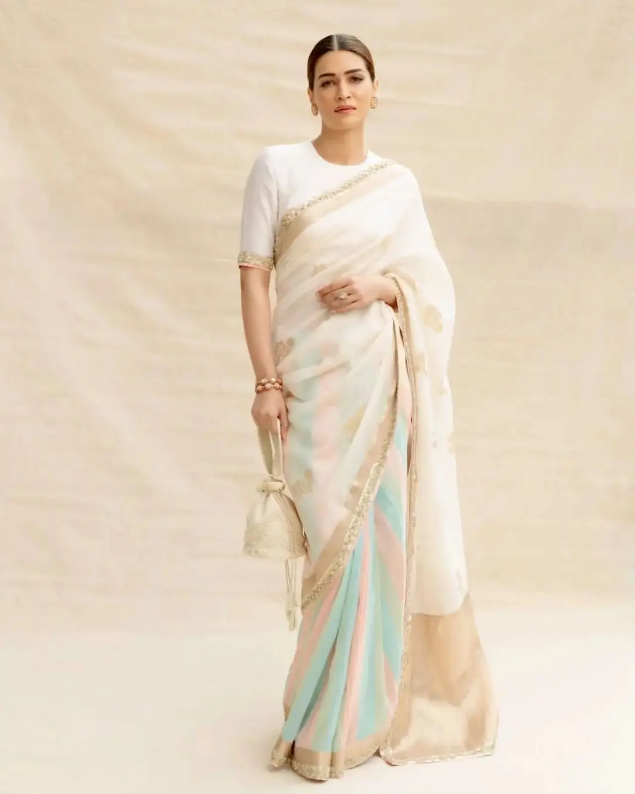 Kriti Sanon attended the ceremony in a stunning cream-colored saree with hints of pink, green, and blue. She had her hair tied in a bun and adorned it with a beautiful `Gajra`