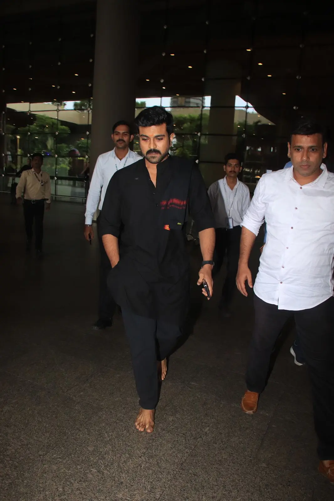 Ram Charan was spotted at the airport wearing an all-black kurta pyjama set while walking barefoot