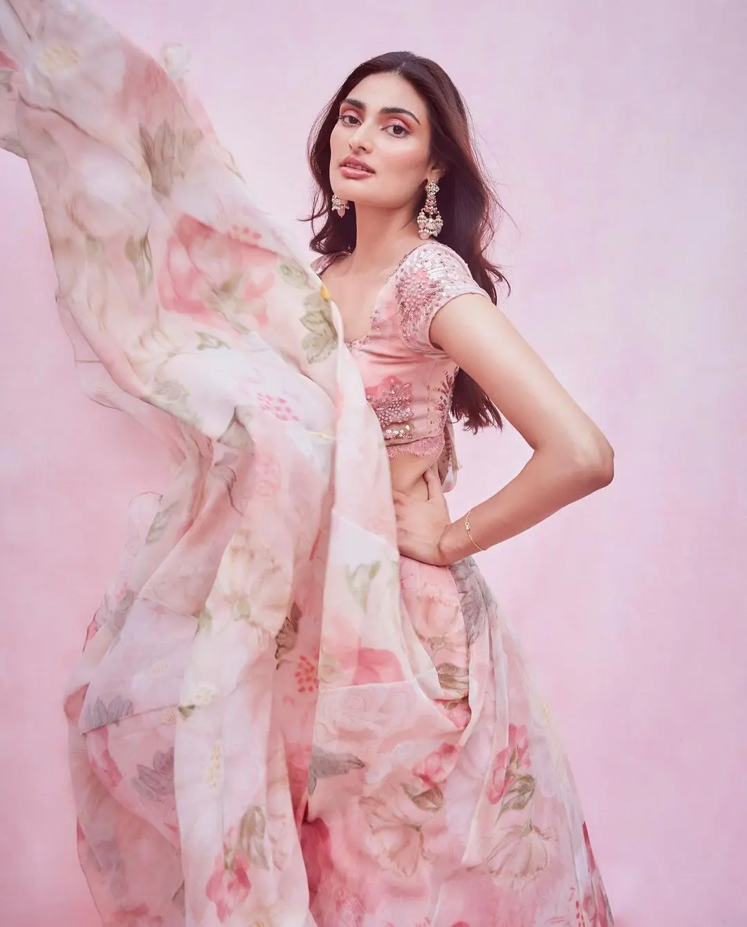 Athiya appeared stunning in a lovely floral lehenga. She`s showcasing her fondness for traditional clothing in a beautiful pink floral-printed lehenga designed by Shehla Khan.