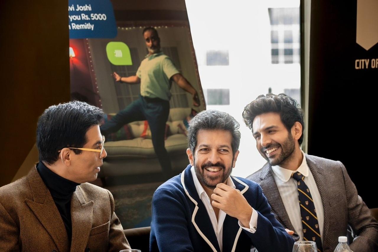 Karan Johar, Kabir Khan, and Kartik Aaryan share a light-hearted moment during a panel discussion on Indian cinema at the festival.