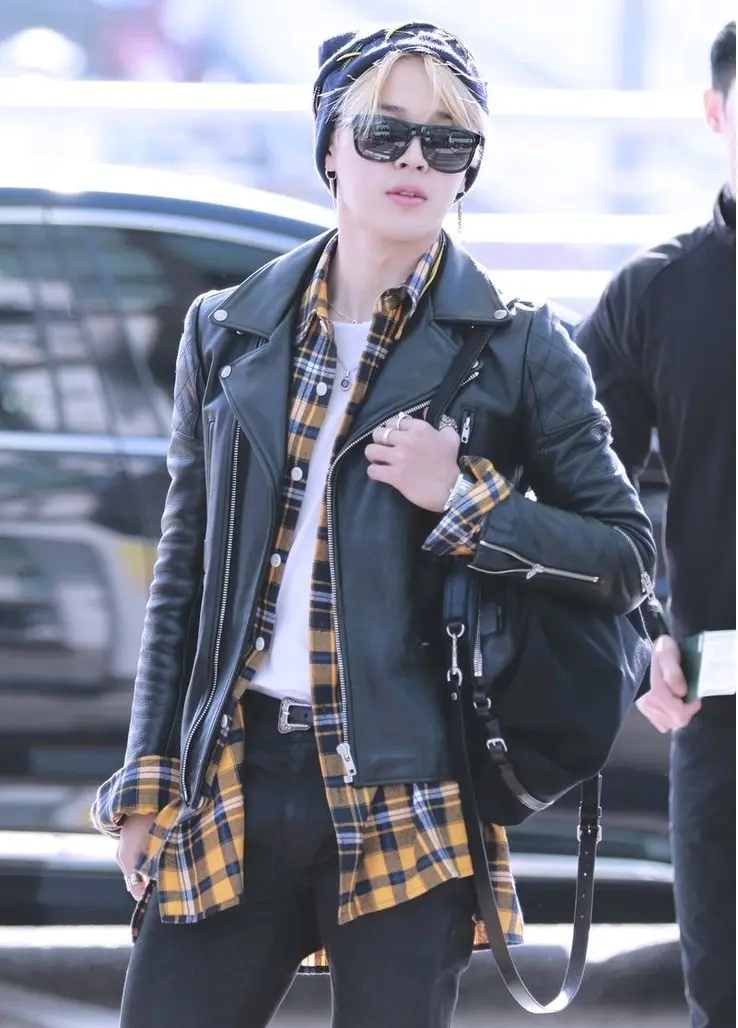 He`s not afraid to rock black jeans with a white undershirt and a yellow flannel overshirt, all topped off with a leather jacket. It`s a blend of grunge and high fashion that only Jimin can pull off.