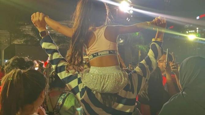 Neha holding her daughter on her shoulders