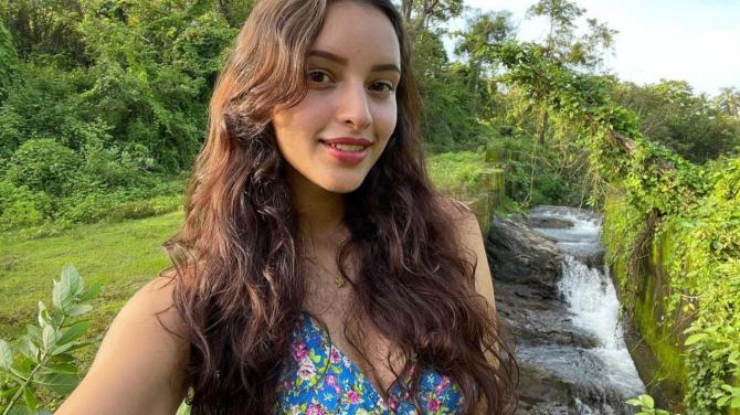Tripti Dimri surrounded by lush green trees