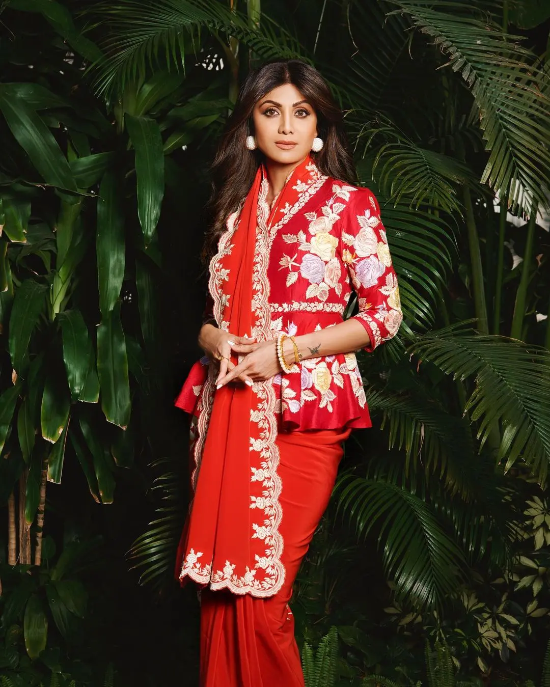 Shilpa Shetty looked absolutely gorgeous in a crimson saree she picked up from Ashdeen`s collection. The saree had a unique peplum style and was adorned with a stunning pattern in soft white and pastel hues. The floral designs on the saree were so captivating, you couldn`t help but be charmed by them.