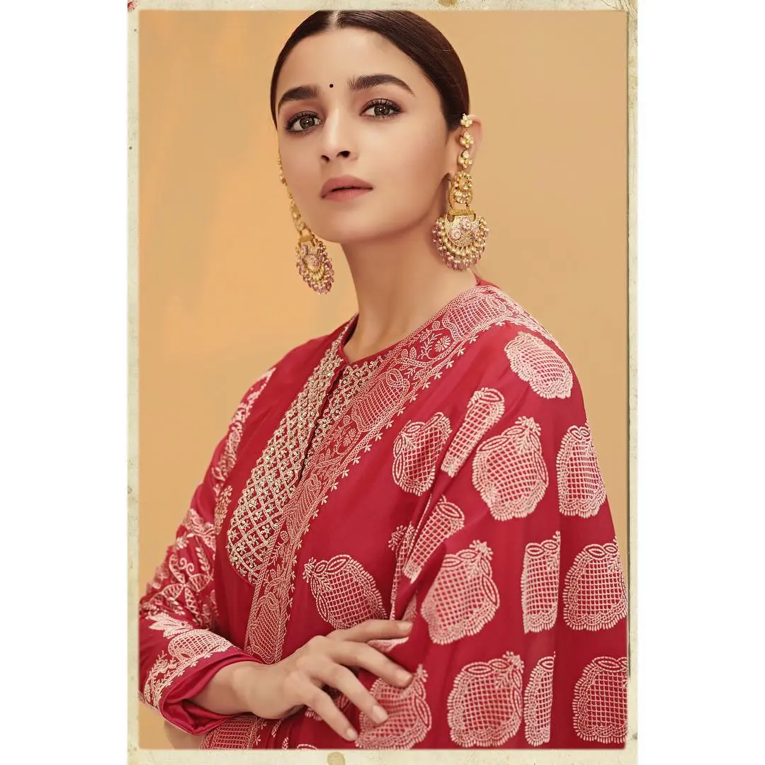 Alia Bhatt looked absolutely stunning in a red Ekaya Banaras kurta set and eye-catching statement earrings, styled by Ami Patel. Her makeup, flawlessly executed by Puneet B Saini, featured a soft brown smoky eye, a matte pink lipstick, and a radiant base with a subtle contour.