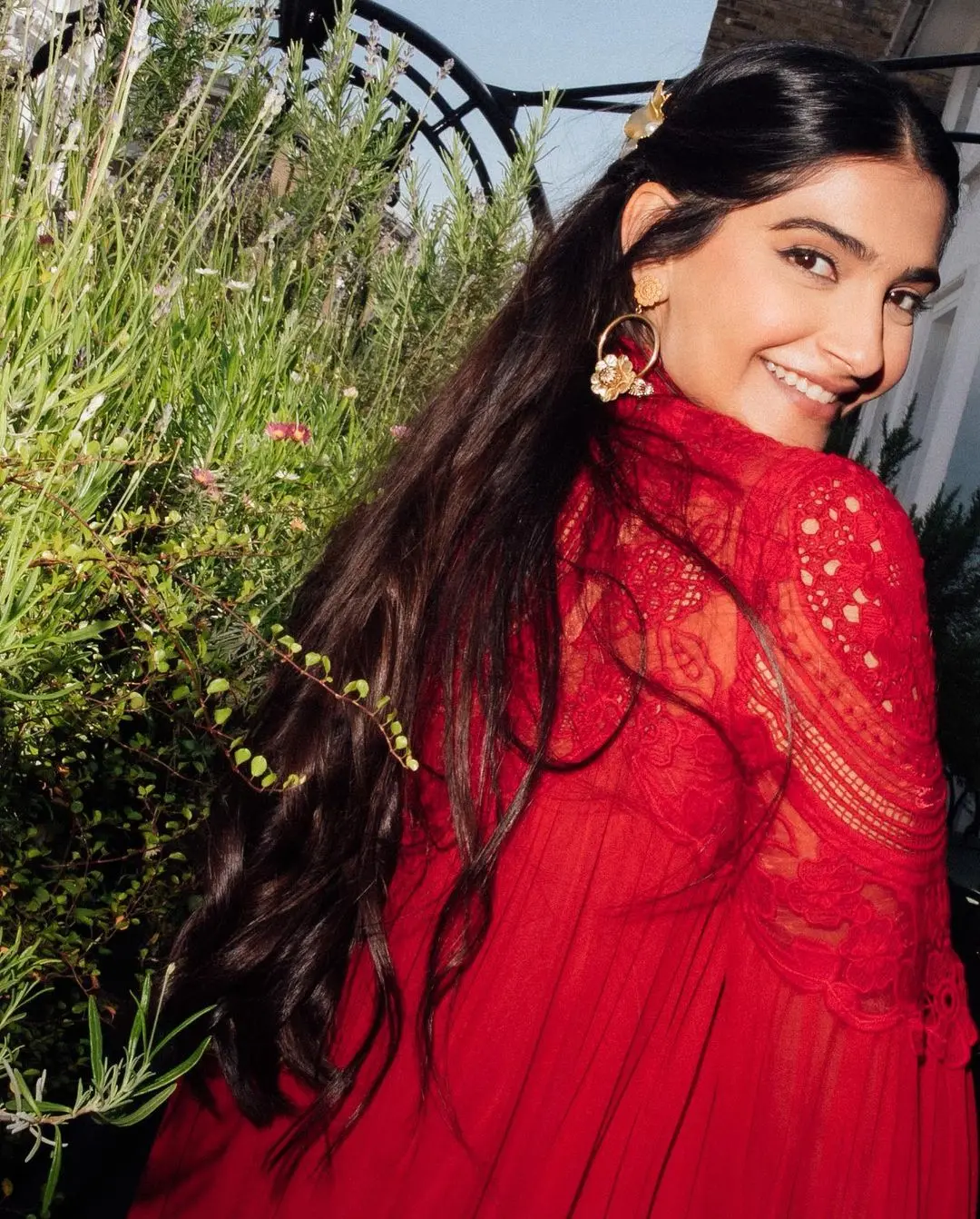 Sonam Kapoor`s birthday outfit is perfect for Navratri Day 2. She wore a stunning ruby red dress from the Greek designer Christos Costarellos` brand, Costarellos. This dress is made of silk chiffon with a high neck and beautiful lace embroidery on the upper half of the bell sleeves and above the bust.