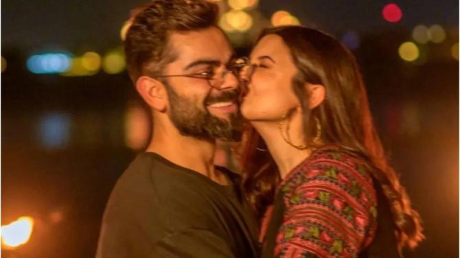 Standing against the citylights, Anushka showing her love for Virat as she plants a kiss on his cheeks.