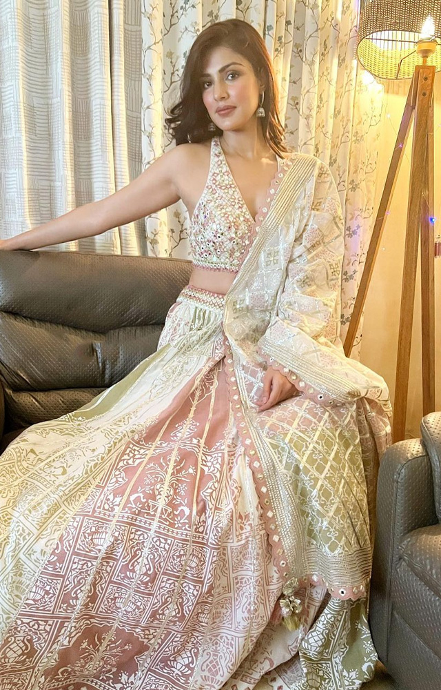 Rhea Chakraborty looks glamorous in this white and pink chic lehenga. The soft undertones of pastels make this ensemble prettier.