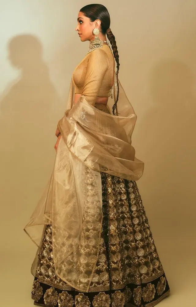 Mom-to-be Deepika Padukone amped up her traditional look with a black and golden lehenga. She styled her hair into a pointy braid.
