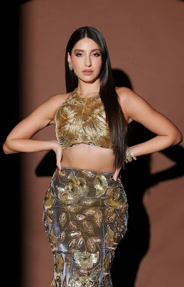 Nora Fatehi made jaws drop in this risque outfit. She wore a golden blouse with a perfectly tailored skirt that complemented her curves