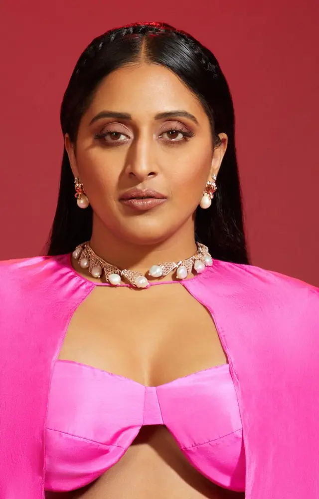 Wearing a striking pink saree, she enhanced it with a matching cape