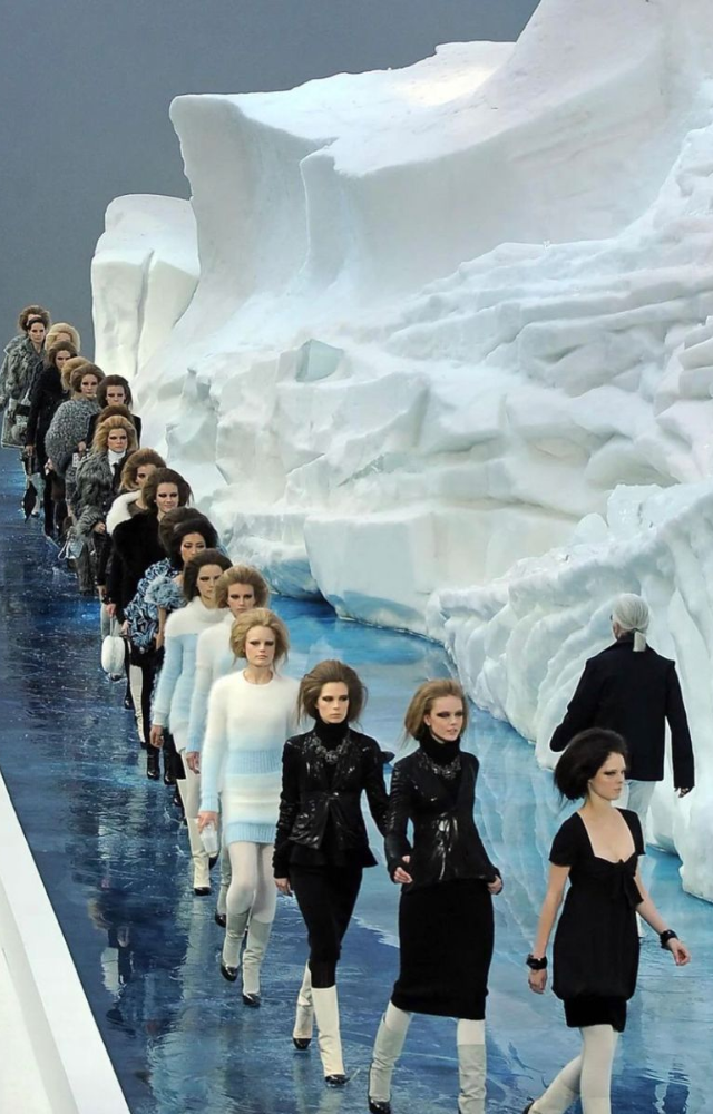 Chanel flew in a real iceberg from Sweden and built it inside the Grand Palais. Models walked in puddles around it—pure drama.
