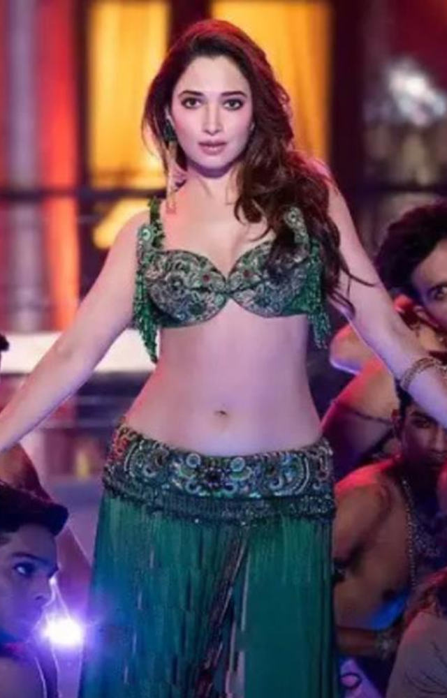 She dazzles in a stunning green outfit that enhances the visual allure of her performance.