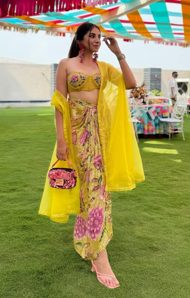Wondering what to wear for your BFF`s haldi ceremony? Take cues from the newlywed and give your traditional wear a twist with a corset top and a long drape.