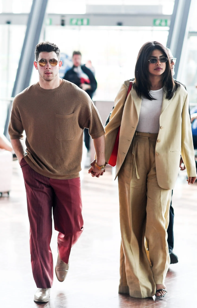 Priyanka`s airport fashion is a perfect fusion of elegance and comfort. She pairs stylish tops with wide-legged trousers or jeans, complemented by sunglasses.