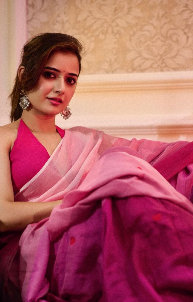 Draped in a pink and purple saree adorned with delicate red heart motifs, Ashika radiates a fusion of contemporary allure and timeless traditional charm.