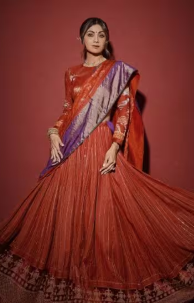 Shilpa Shetty radiated in a traditional red and gold saree, beautifully accessorized with elaborate gold jewelry and a gajra in her hair.