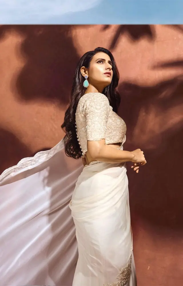 Fatima looks dreamy in this white saree. The contrasting jewelry and her open hair just amps up the look