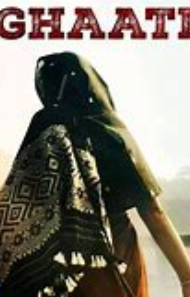 She is seen wearing a saree, covered with a black shawl, and adorned with traditional jewelry.