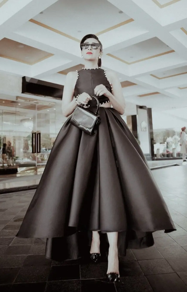 The dress, made from luxurious Mikado fabric, featured a sleeveless design adorned with delicate pearl embellishments around the round neckline.