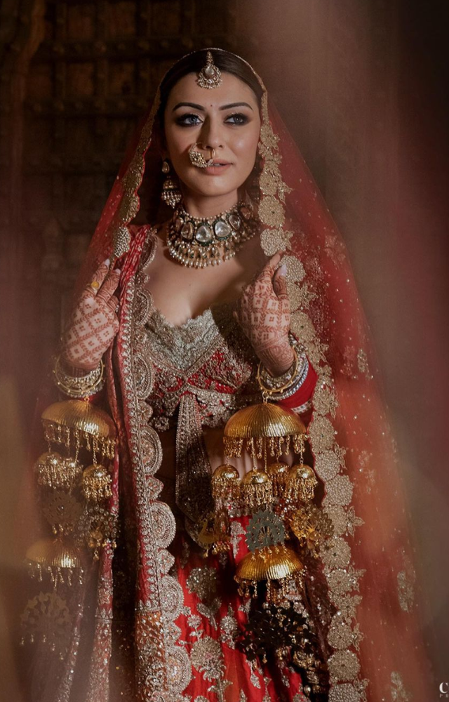 Hansika chose a majestic appearance, donning a richly embroidered red lehenga paired with gold jewelry and a classic maang tikka