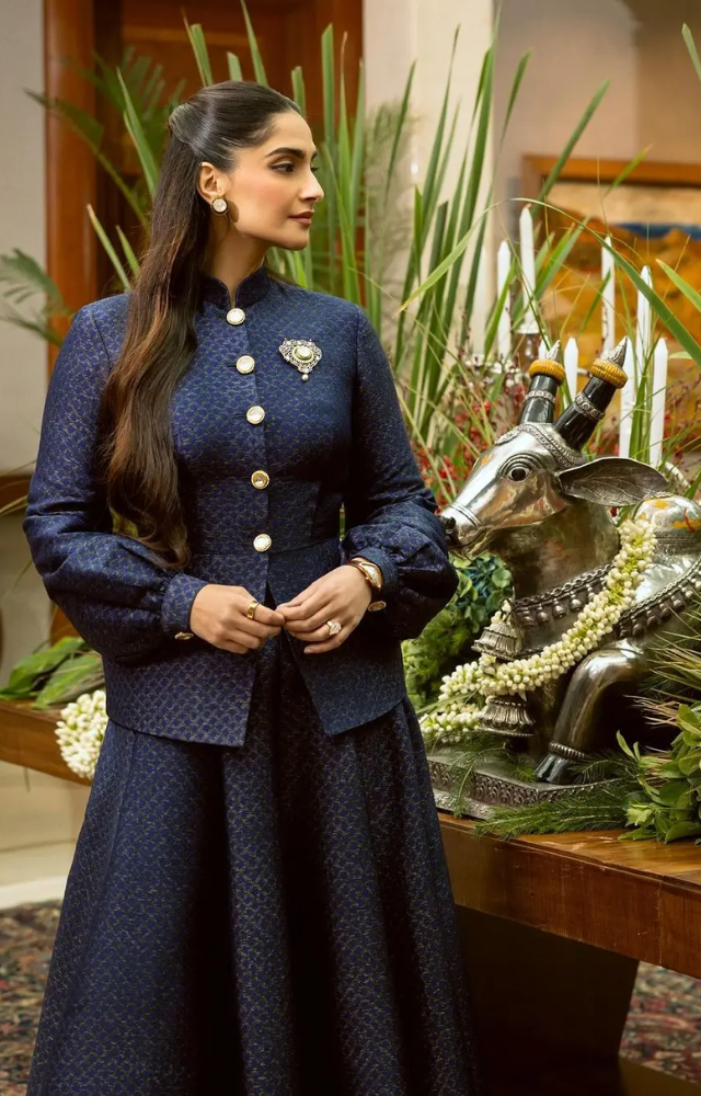 Sonam Kapoor wore a custom royal blue outfit by Kunal Rawal, featuring balloon-like sleeves and a full-sleeved, closed dark blue shirt with golden buttons.