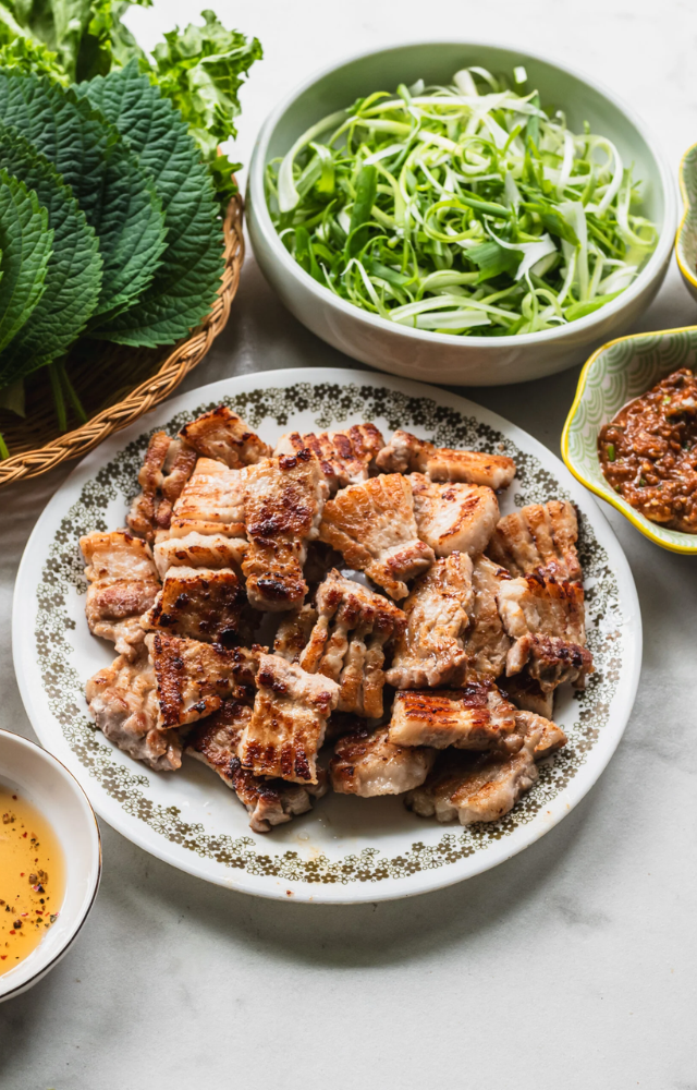 Thick slices of pork belly, grilled and enjoyed with various side dishes. 