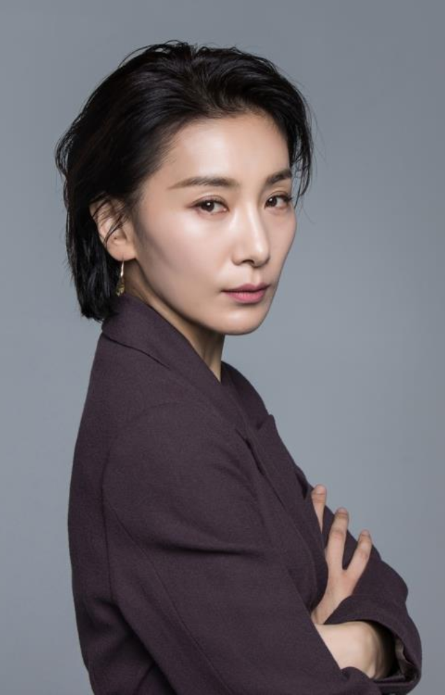 As a highly sought-after and ruthless college entrance exam coordinator, her sharp, powerful, and impeccably tailored outfits reflect her cold behaviour