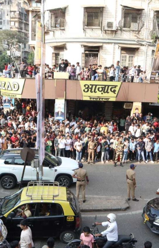 Fans gathered on the footpath, rooftop of shops while some looked through the window of their house