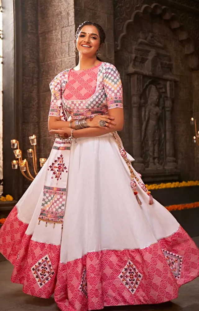 The traditional chaniya choli for Garba consists of a colorful, embroidered skirt and matching blouse, featuring mirror work, beads, and intricate designs