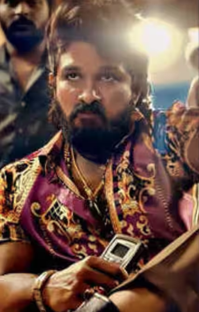 Pushpa escapes jail, shot 8x, hides in forest. Rumors of death, riots ensue. He’s alive, poses with tiger, ends in pink shirt, goons around.