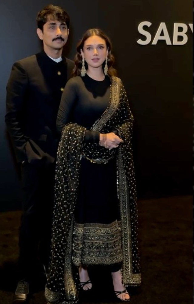 A black Anarkali suit with intricate golden detailing.