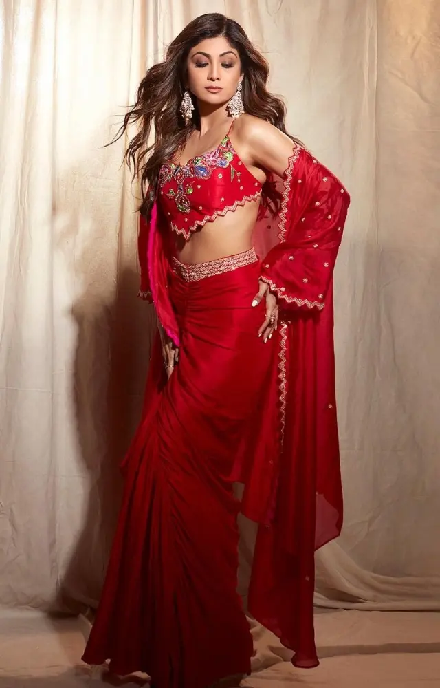 Shilpa Shetty wore a bright red coloured dhoti-style skirt and paired it with a blouse. She completed the look with a matching jacket