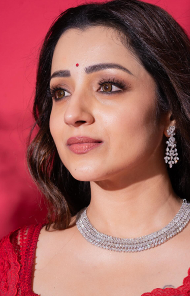Trisha shines in a red saree like a precious gem.