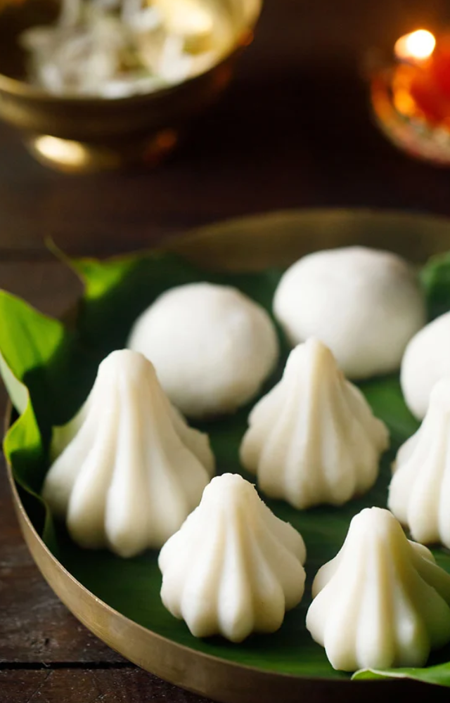 Steamed rice dumplings filled with jaggery and coconut, often prepared during festivals like Ganesh Chaturthi.