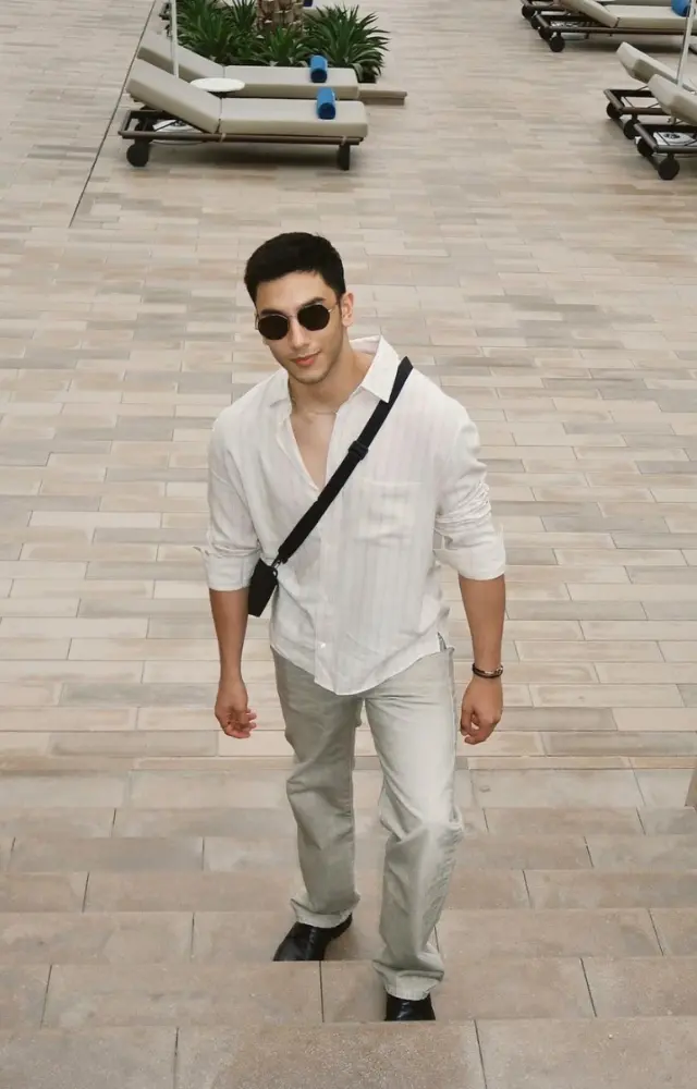 Embracing summer vibes, Vedang Raina looks fresh and breezy in a white cotton shirt and light-toned pants, accessorized with a cross-body bag and sunglasses
