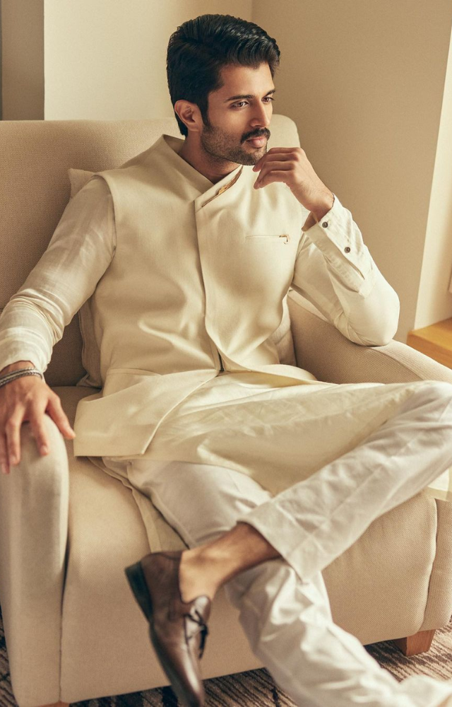 Vijay exudes unparalleled charm and style in his all-white ensemble, effortlessly paired with striking brown shoes for the perfect contrast